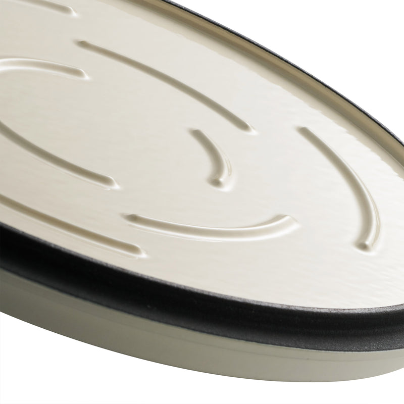 Close-up of a white oval-shaped dutch oven  with black rim on a white background