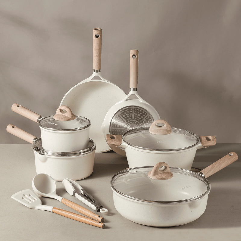 Set of white cookware with wooden handles on a gray surface
