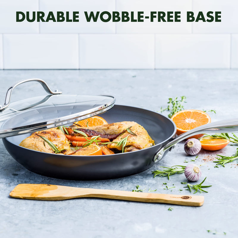 Non-stick greenpan frying pan with food and ingredients on a light blue surface, featuring text 'Durable Wobble-Free Base'.