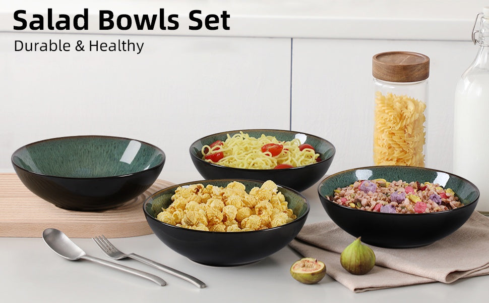 Set of black salad bowls with various contents on a white surface, with a jar of pasta in the background.
