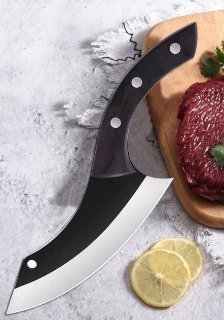Large knife with a black blade and silver handle on a cutting board with raw meat and lemon slices.