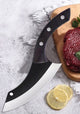 Large knife with a black blade and silver handle on a cutting board with raw meat and lemon slices.