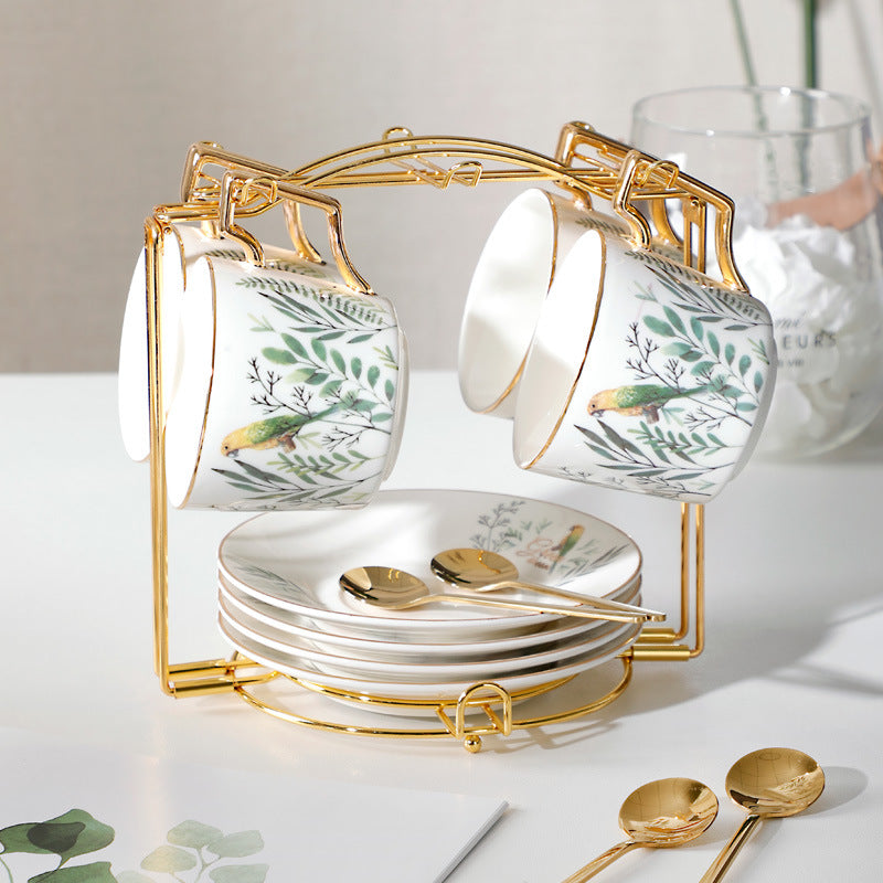 Set of ceramic tea cups and saucers with gold accents on a white surface