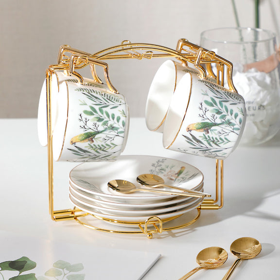 Set of ceramic tea cups and saucers with gold accents on a white surface