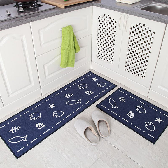 Navy blue kitchen mats with white patterns on a white floor in a kitchen setting.