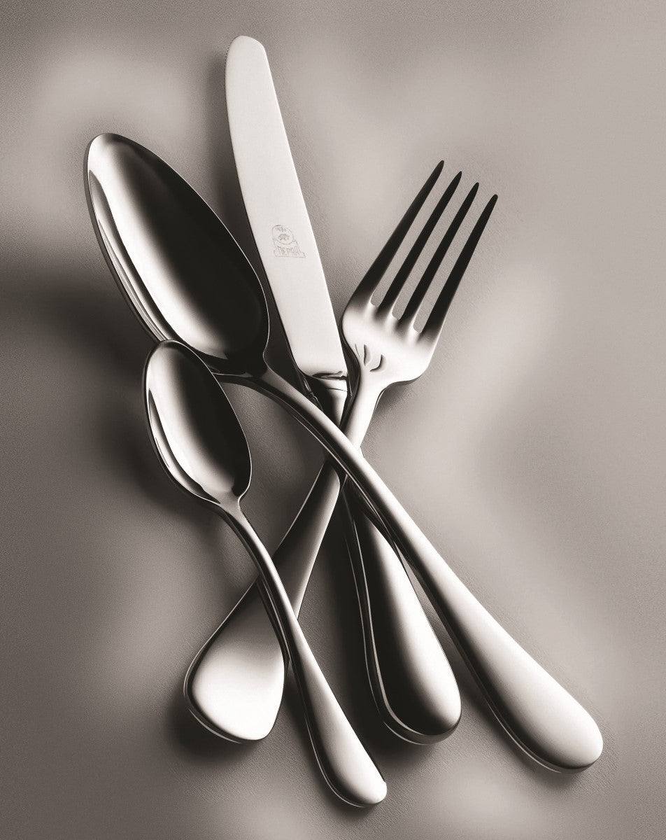 Set of silver cutlery including a knife, fork, and two spoons on a reflective surface.