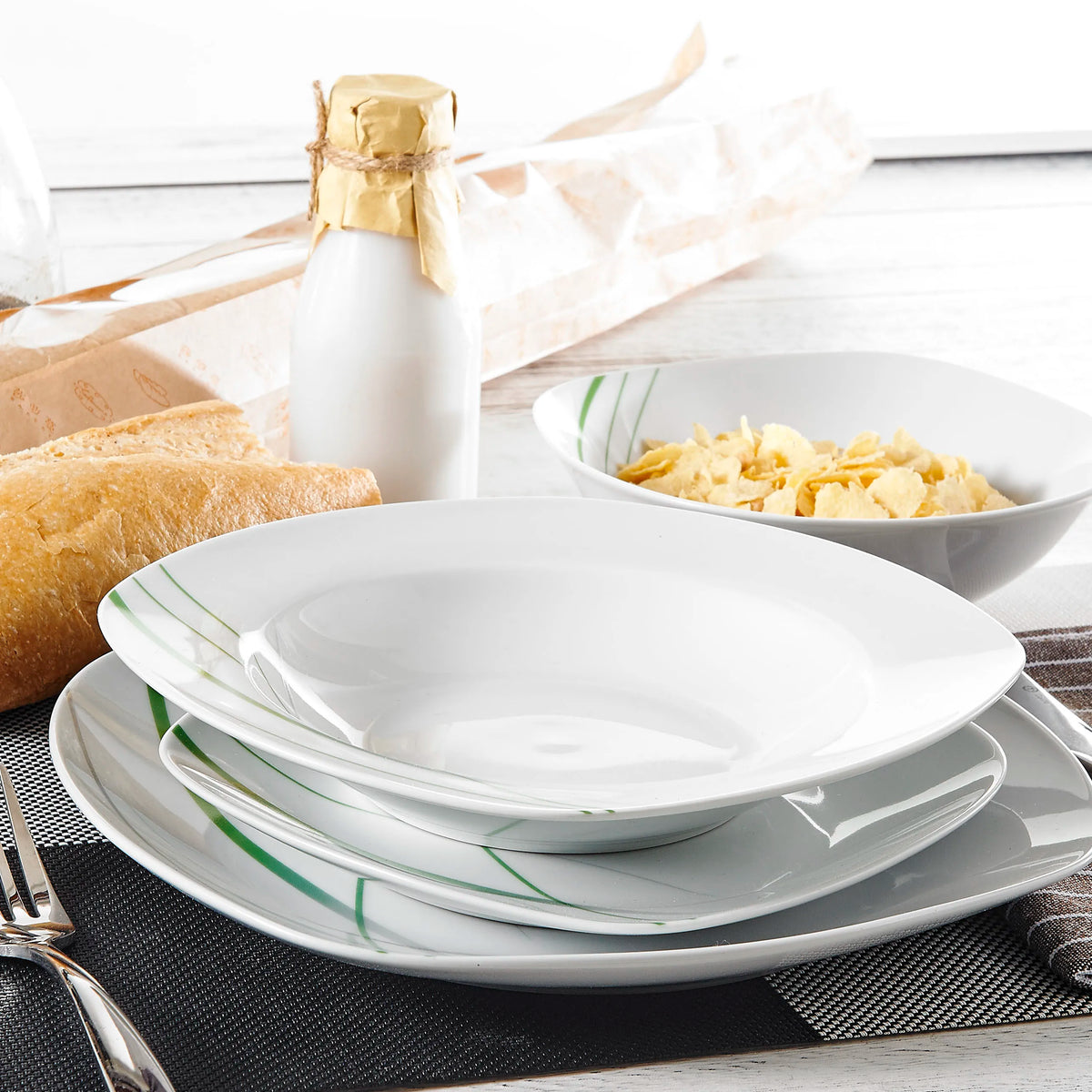 White dinnerware set on a table with pasta and bread