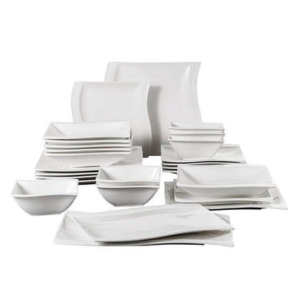 Set of white ceramic dinnerware including bowls and plates on a white background
