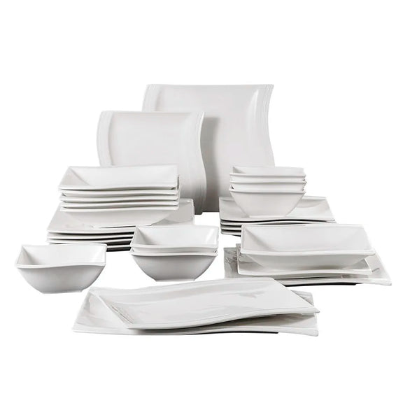Set of white ceramic dinnerware including bowls and plates on a white background