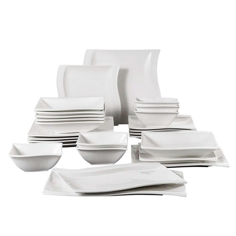 Set of white ceramic dinnerware including bowls and plates on a white background