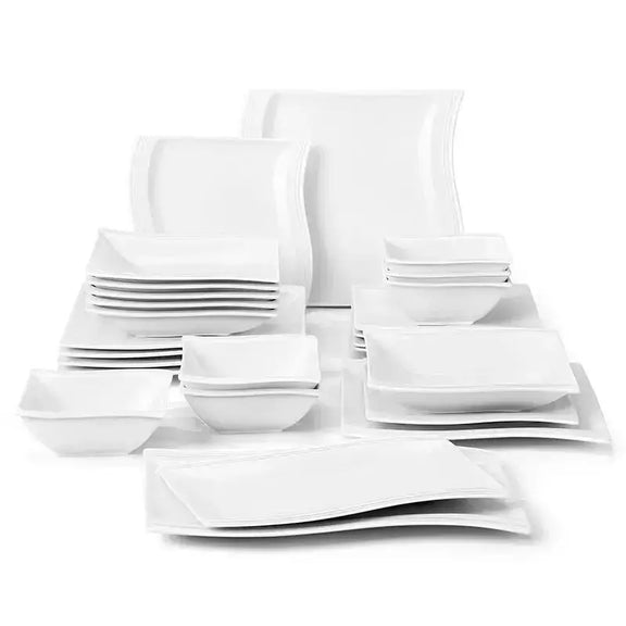 Set of white ceramic dinnerware including plates, bowls, and cups on a white background