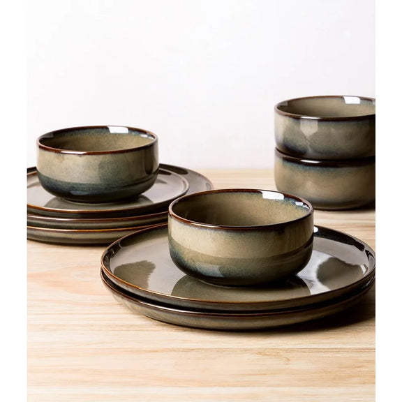Set of ceramic bowls and plates with a brown and beige glaze on a wooden surface.