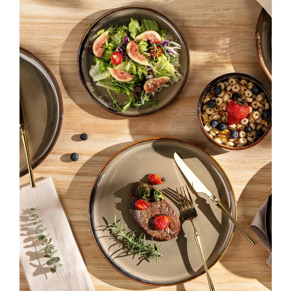 Dinner setting with a plate of food, salad, and cereal bowl on a wooden table.