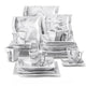 Set of white ceramic dinnerware with marble-like pattern on a white background