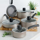 Set of cookware with lids on a kitchen counter and cutting boards