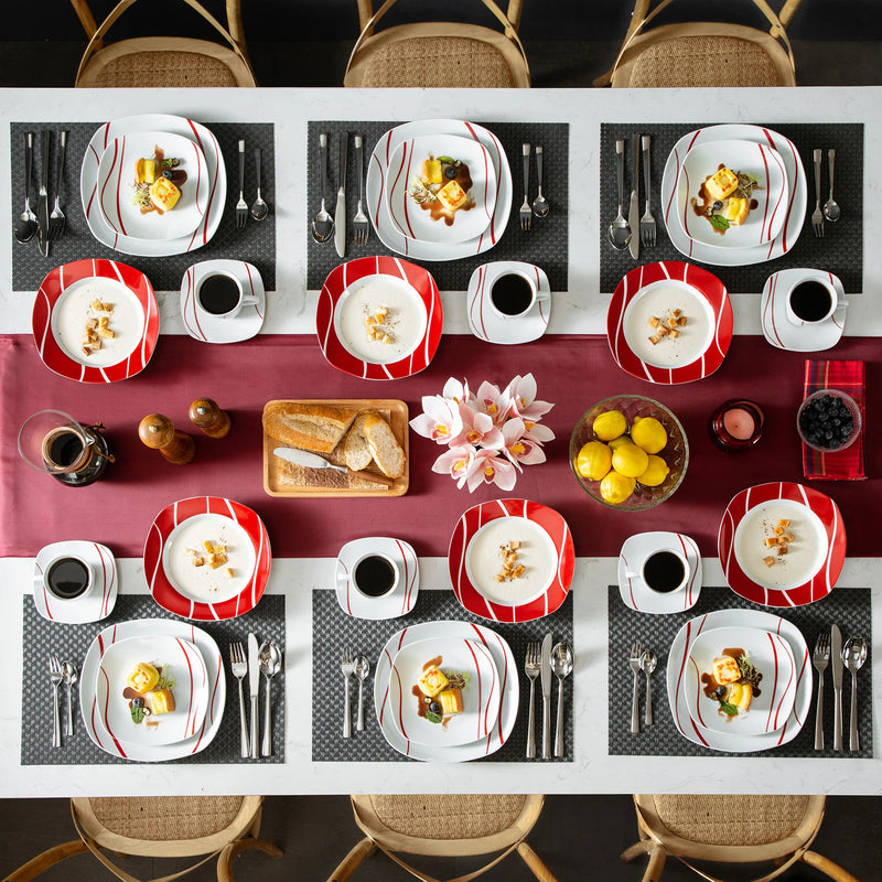 Dining table set with plates, cups, and food arranged on a checkered tablecloth.