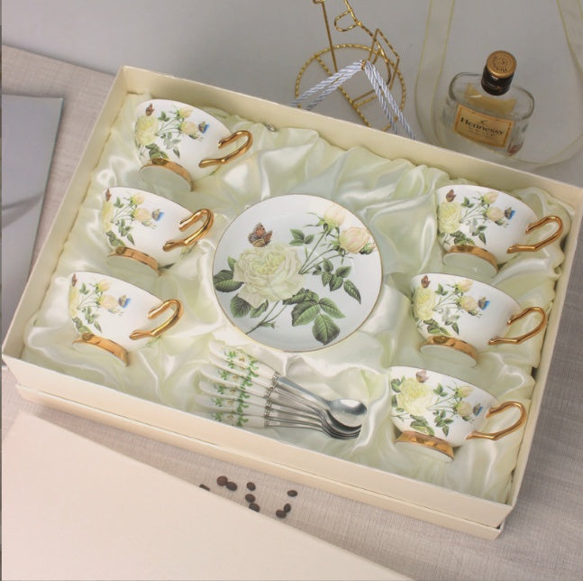 Set of ceramic tea cups and saucers with floral designs in a decorative box.
