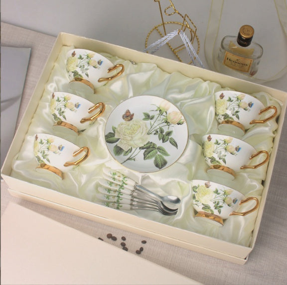 Set of ceramic tea cups and saucers with floral designs in a decorative box.