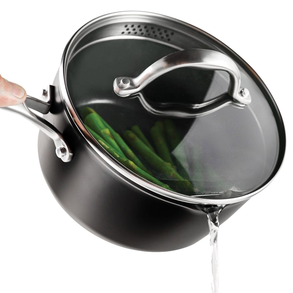 Black pot with asparagus with a glass lid draining off water on a white background