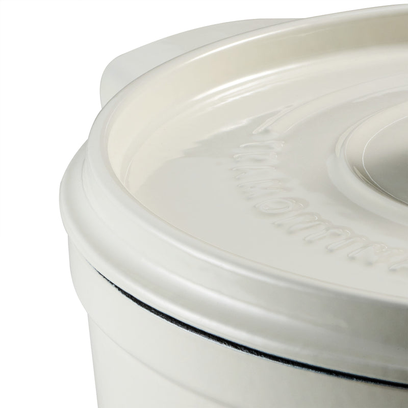 Close-up of a white dutch oven with a lid on a white background