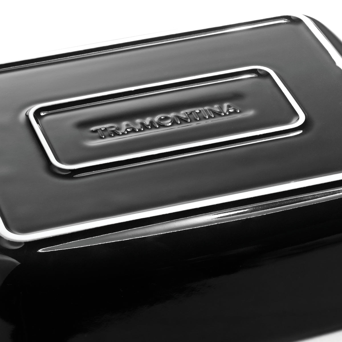 Close-up of a black container with a silver logo on a white background