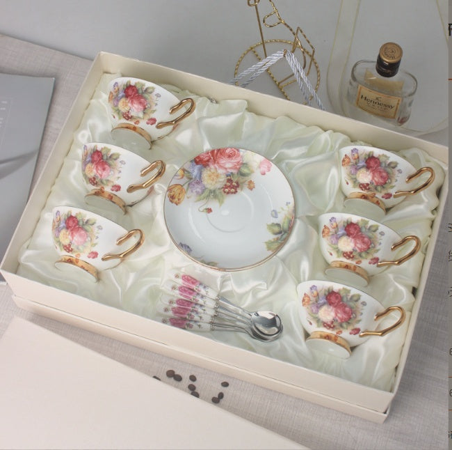 Set of ceramic tea cups and saucers with floral designs in a decorative box.