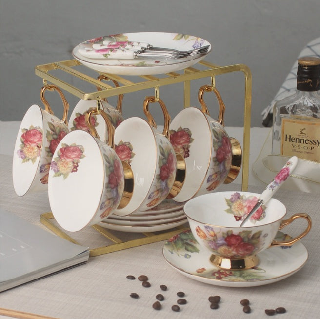 Set of floral teacups and saucers with a Hennessy VSOP cognac bottle in the background.