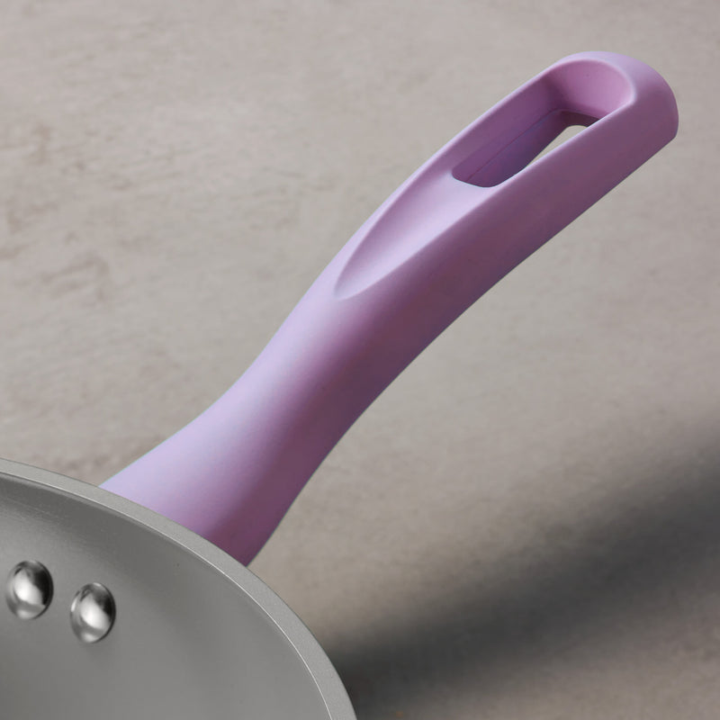 Purple handle of a frying pan on a neutral background
