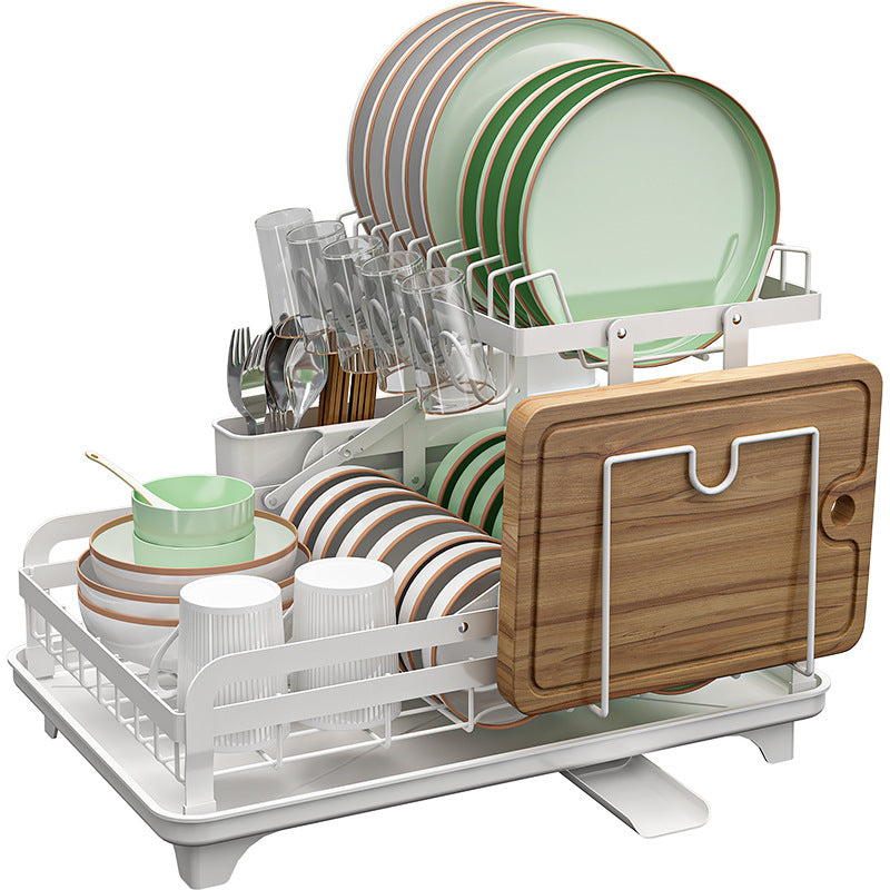 Dish drying rack with green plates, cups, glasses, and a wooden cutting board on a white background