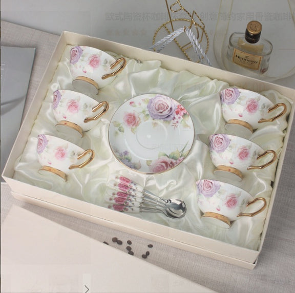 Set of ceramic tea cups and saucers with floral designs in a decorative box.