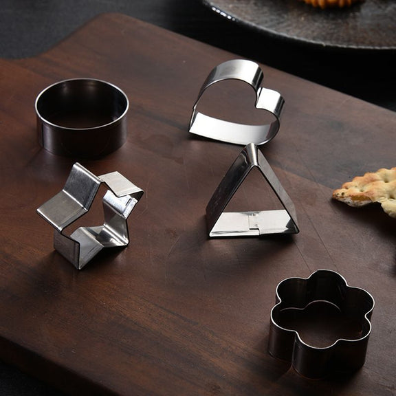 Set of metal cookie cutters on a wooden surface with a rustic background.