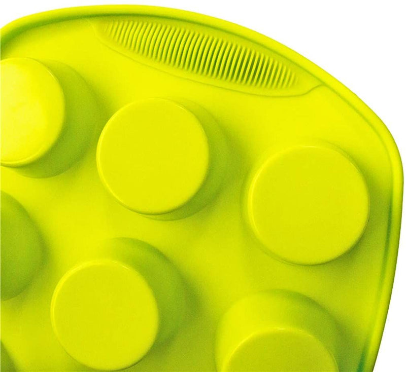 Close-up of a green silicone mold with circular cavities on a white background