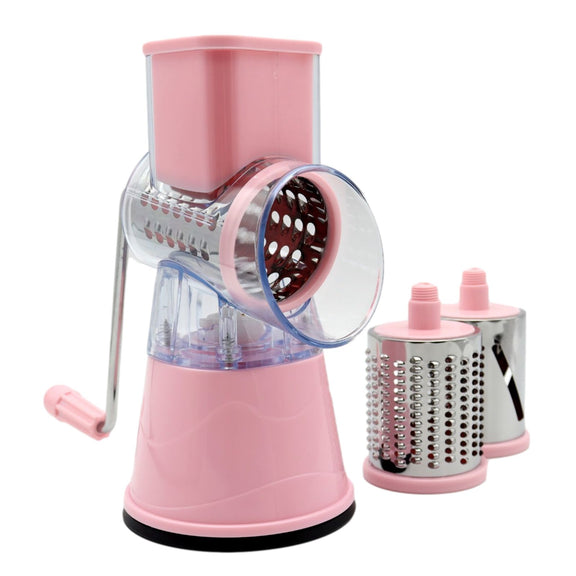 Pink manual rotary cheese grater with three interchangeable metal grating drums on a white background