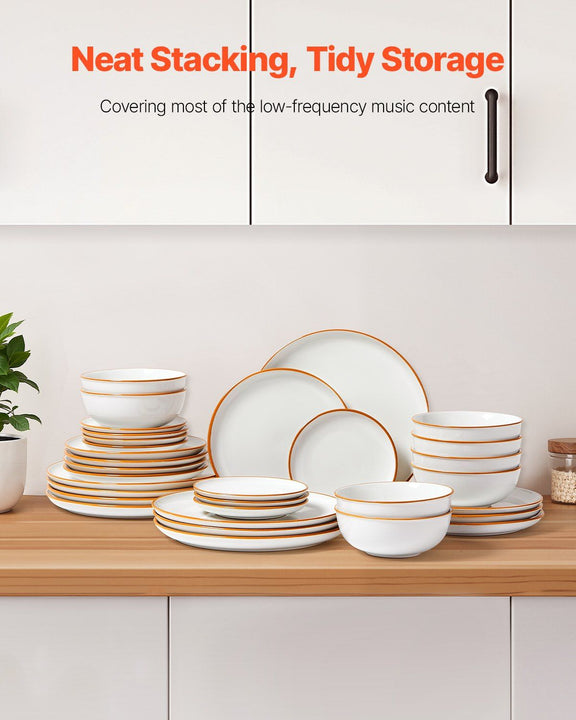 White dinnerware set with gold rims on a wooden shelf against a white cabinet background.