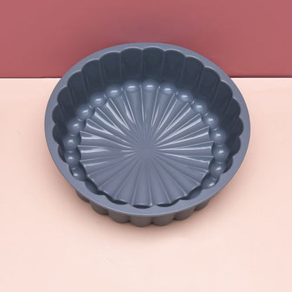 Blue fluted baking dish on a pink background