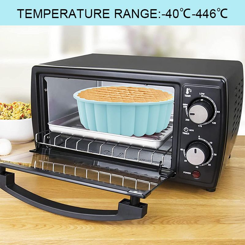 Black toaster oven with a blue silicone mold inside on a wooden surface.