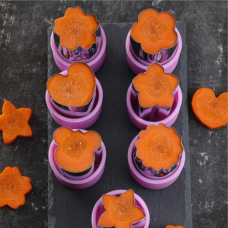Purple silicone mold with orange cookie shapes on a dark surface
