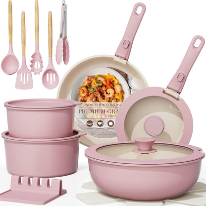 Pink cookware set with utensils and a pan on a white background