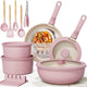 Pink cookware set with utensils and a pan on a white background