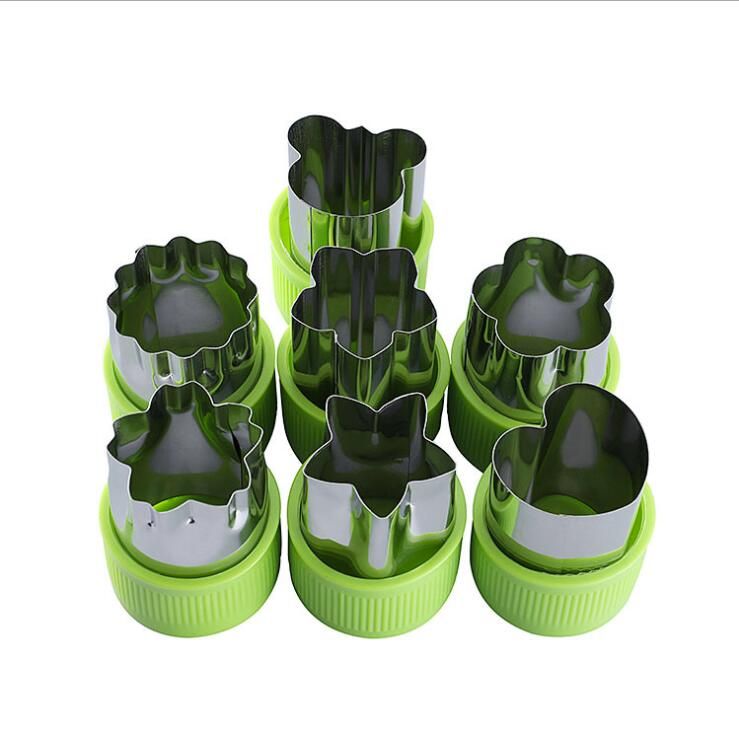 Set of green cookie cutters with various shapes on a white background
