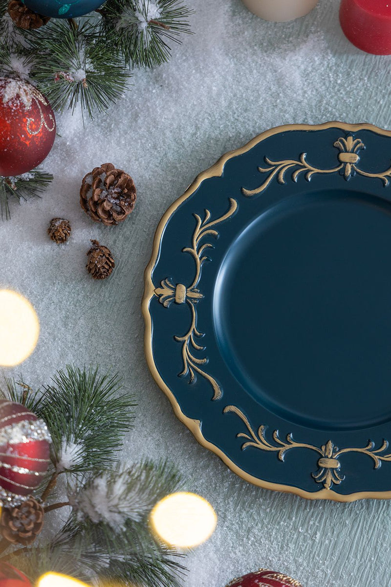 Decorative blue plate with gold rim on a festive background with Christmas ornaments and lights.