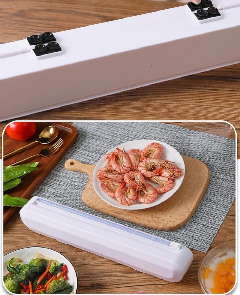 Vacuum sealer on a wooden table with food items around