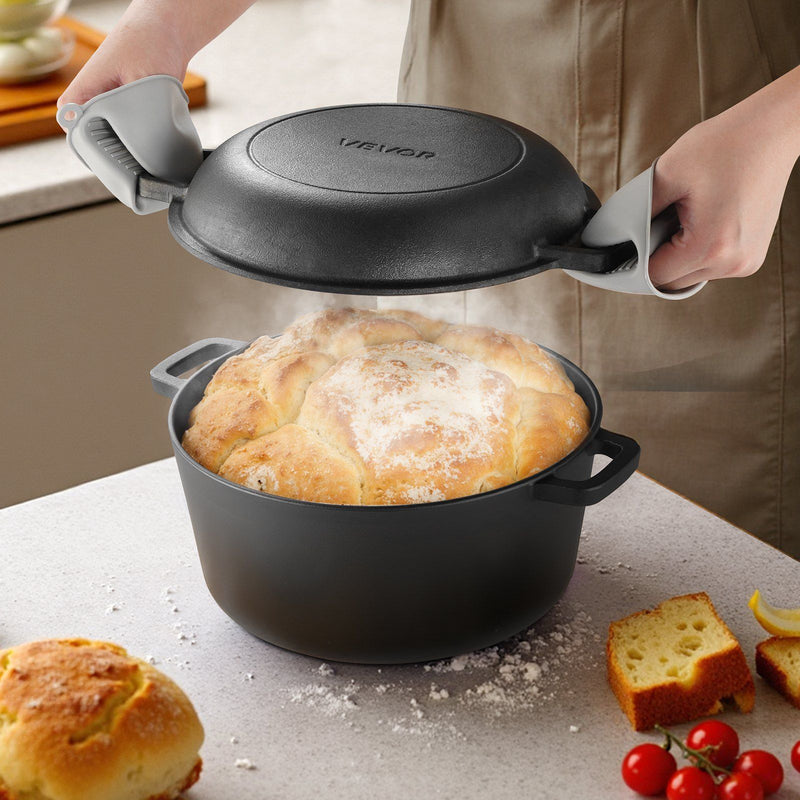 Person lifting the lid of a black cast iron pot containing bread, with a kitchen setting in the background.