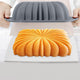 Bundt cake being removed from a gray silicone bundt pan on a white surface.