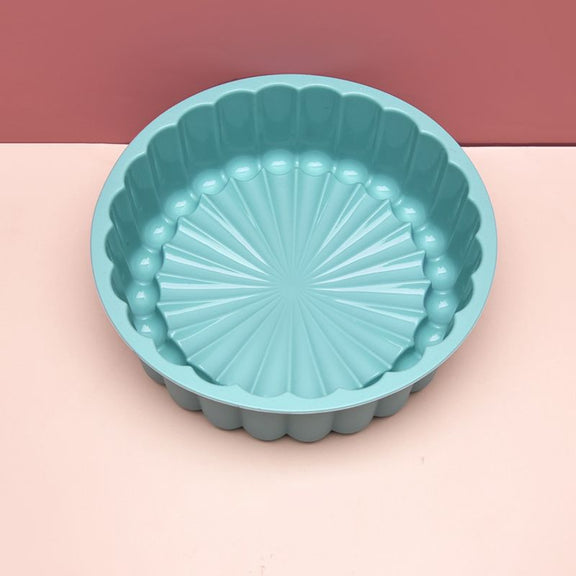 Teal silicone baking mold on a pink background