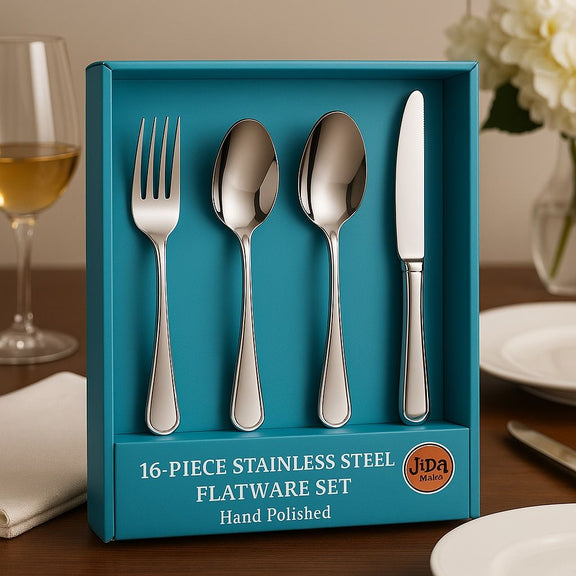 16-piece stainless steel flatware set in a blue box on a table with a glass of wine and flowers.