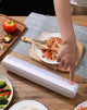 Person using a vacuum sealer on a table with food items