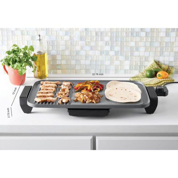 Electric grill with food on a kitchen counter, showing dimensions.