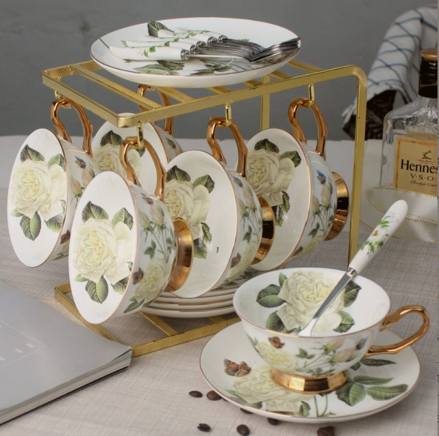Tea set with floral design on a gold stand, featuring a cup, saucer, and plates.