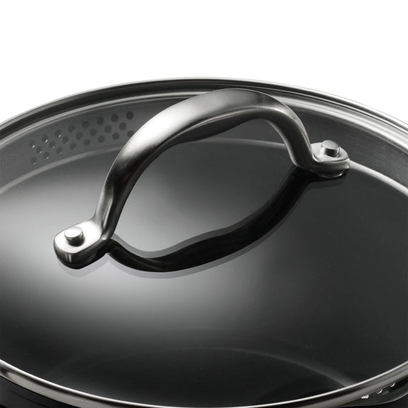 Close-up of a black pot lid with a metallic handle on a white background